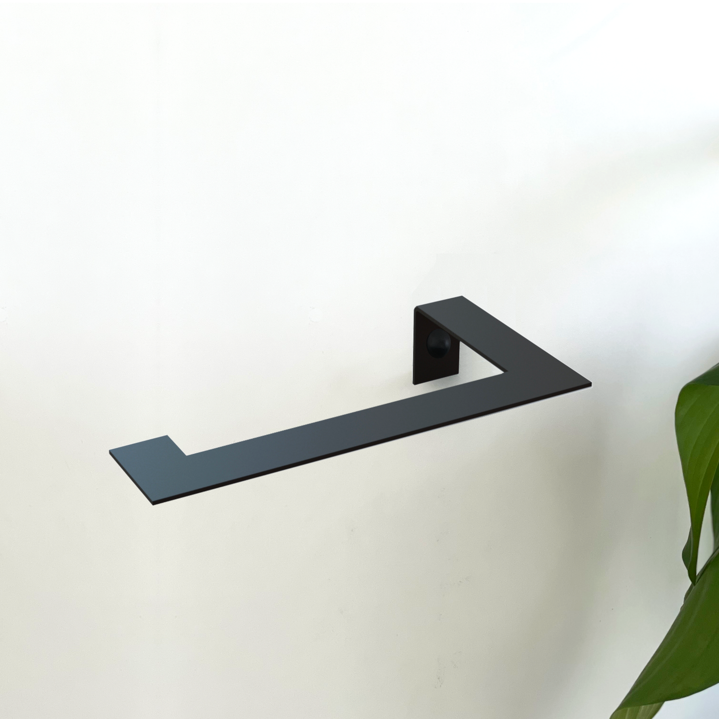 A black steel toilet paper holder or black metal toilet roll holder in a modern bathroom design store in Johannesburg with an indoor bathroom plant from Mr price home