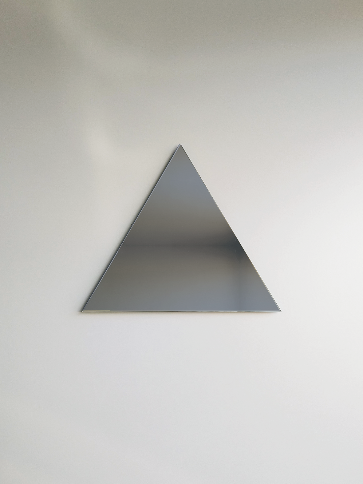 large wall mirror or large bathroom mirror in south african designers furniture store in Johannesburg. The triangle mirror is grey glass colour.