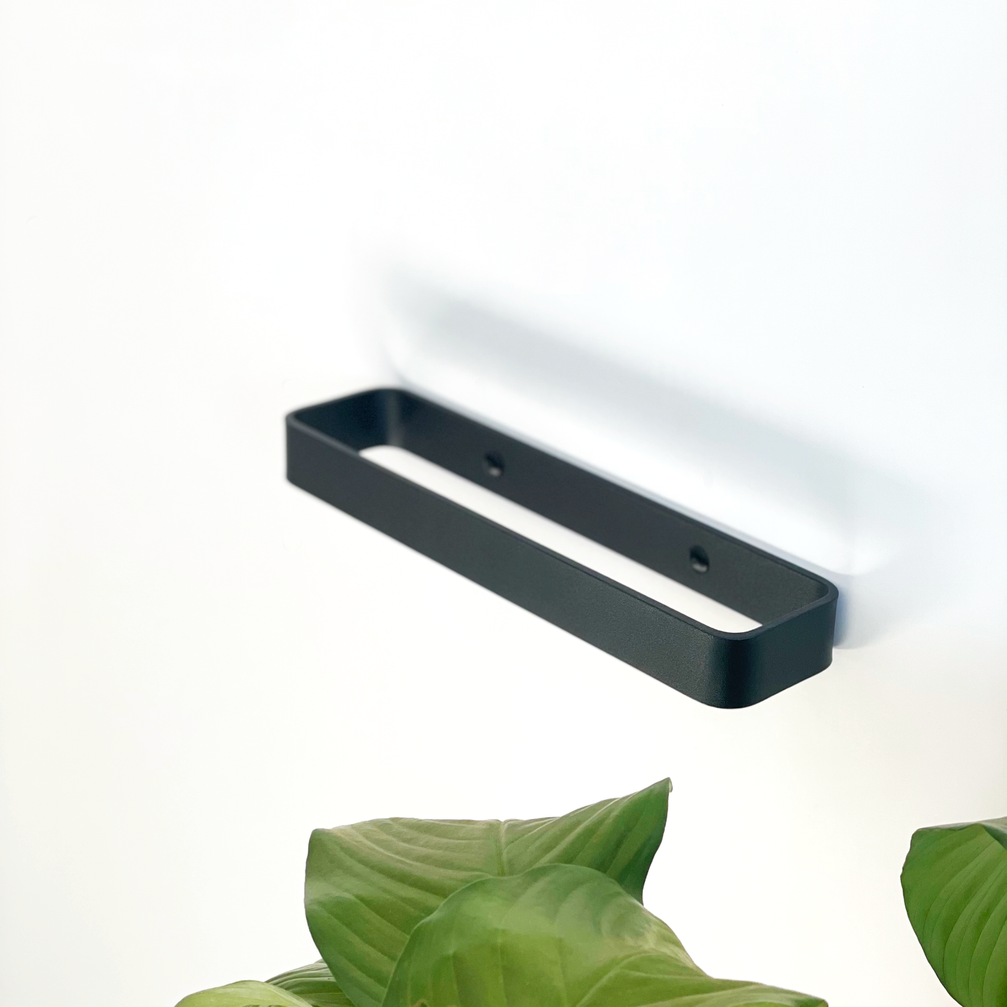A black steel towel rail or a black metal towel rail in a Johannesburg bathroom store with an indoor plant from Mr Price Home