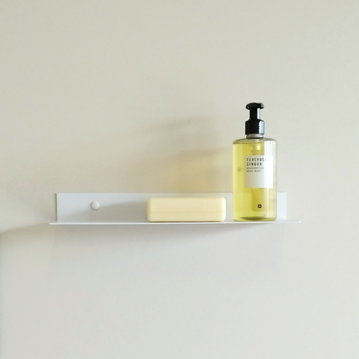 White steel shower shelf or bathroom shelf or white steel shower caddy with artisanl soap and soap dispenser from Mr Price home in Luxury bathroom design store in Johannesburg