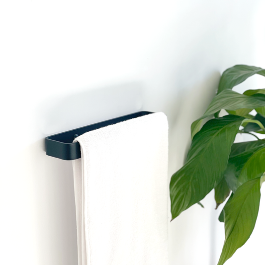 A black steel towel rail with a white towel from Mr Price Home and an indoor plant in a Johannesburg bathroom ideas store
