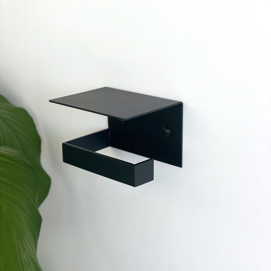 This black steel toilet paper holder or black steel toilet roll holder with shelf is a combination product in a south african design bathroom store in Johannesburg with an indoor bathroom plant from Mr Price home