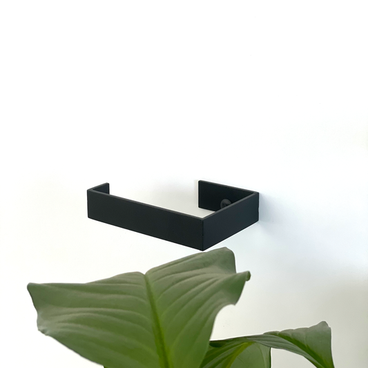A black steel toilet paper holder or black metal toilet roll holder in a modern bathroom design store in Johannesburg